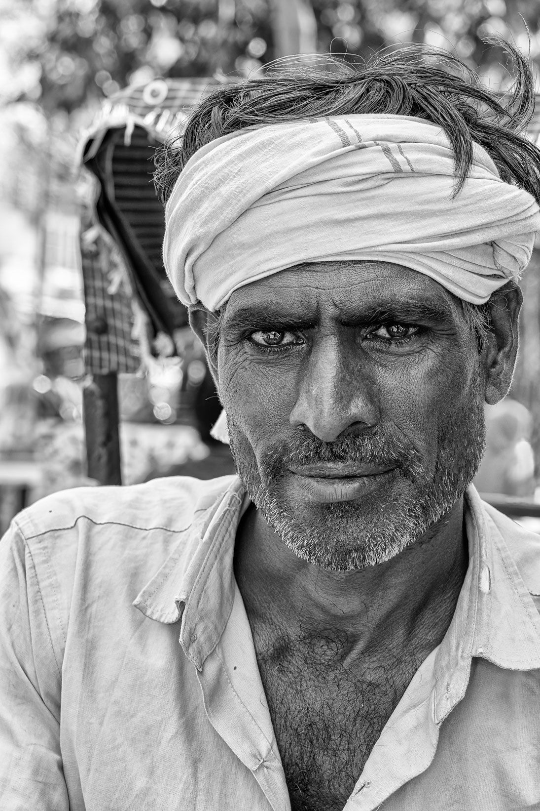 Black and white portrait of a man in a white turban looking into the camera